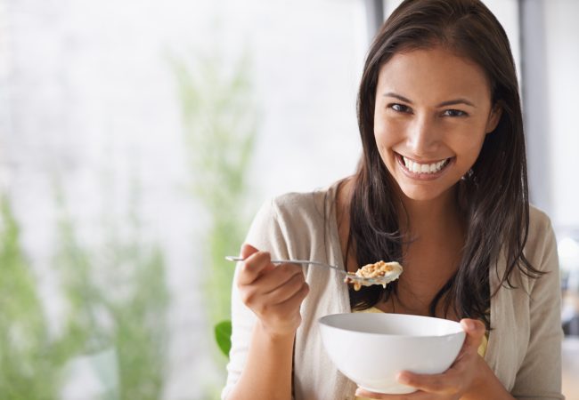 A lovely young woman enjoying a bowl of cereal